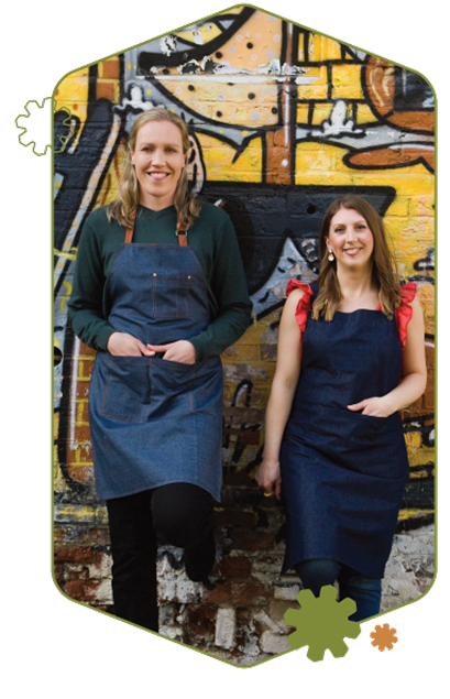 repair-member-us-image-2 We Are Repairs founders Ally Booker and Gemma Broad leaning against a graffitied wall in central Nottingham.