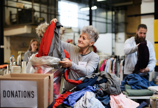 donating-clothes Woman sorting through donated clothing