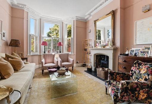 muse-bespoke-01 Pink painted living room with beautiful fireplace, sofa and three restored upholstered chairs