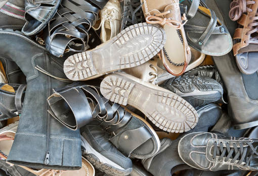 shoe-waste-pile Woman sorting through donated clothing