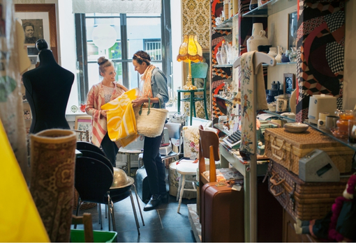 sustainable-christmas-03 Two women shopping in a vintage shop, full of vintage homeware and furniture