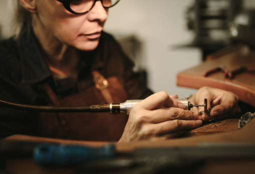 woman-repairing-jewellery-04 A female jeweller in her workshop repairing a ring