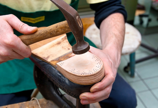 cobbler-fixing–a-new-sole-to-shoe-06 A cobbler fixing a new sole to a shoe